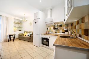 uma cozinha com electrodomésticos brancos e um sofá num quarto em Casa Olga em Rota