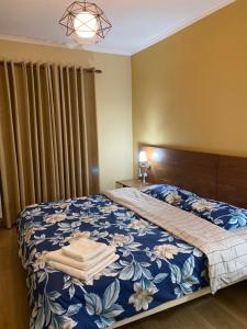 Un dormitorio con una cama azul y blanca con toallas. en Bujtina Vasili, en Korçë