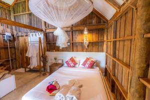a bedroom with a bed in a wooden room at Nakhao Cottage in Ban Wat Tan