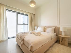 a bedroom with a large bed with two towels on it at Lavishly Elegant 2BR with Breathtaking Full Burj Khalifa View in Dubai