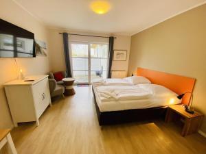 Un dormitorio con una cama grande y una ventana en Landhaus Immenbarg, Lobby, en Warnemünde