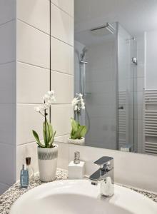 a white bathroom with a sink and a mirror at Landhaus Immenbarg, Poseidon in Warnemünde