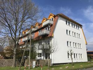 a white building with balconies on the side of it at Landhaus Immenbarg, Seeteufel in Warnemünde