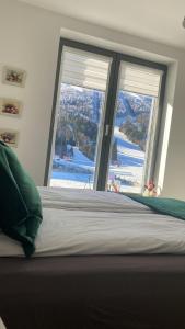 a bedroom with a bed and a window with a view at Divernoa Mountain Bjelašnica in Bjelašnica