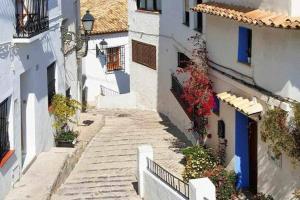 an alley between two buildings with stairs and flowers at The Dreamer Balcón con Vistas al Mar by Vero in Altea