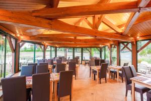 een eetkamer met houten tafels en stoelen bij L'Oustal de Vézac in Vézac