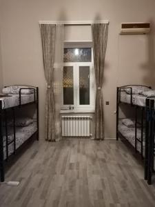 a room with two bunk beds and a window at Eminera Hostels Baku in Baku
