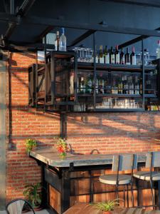 a brick wall with a bar with a table and chairs at SuanGlangNa in Phrae
