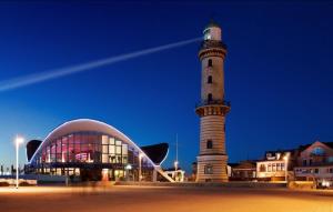 un faro junto a un edificio y un edificio en Mond, am Warnemünder Kirchenplatz, en Warnemünde