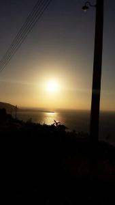 zachód słońca nad oceanem i słońce na niebie w obiekcie Aretis sea view house w mieście Pachyammos