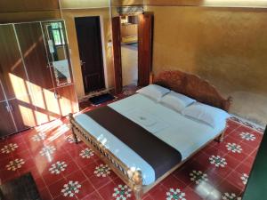 1 dormitorio con cama y espejo en una habitación en Chithira Homestay (Kerala traditional mud house), en Kodali