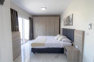 Schlafzimmer mit einem Kingsize-Bett und einem Tisch in der Unterkunft Seafront Penthouse in St Paul's Bay