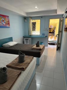a room with two beds and a hallway with a unintention at Koh Chang Baanrimtalay in Ko Chang