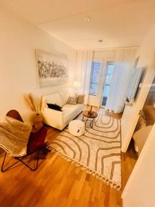 een woonkamer met een witte bank en een tapijt bij 2 Room / Central Railway / Free parking in Seinäjoki