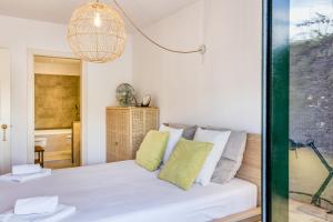 Habitación con cama blanca y ventana de cristal. en Villa Virginie Torremirona Resort, en Navata