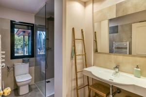 une salle de bain avec un lavabo, des toilettes et un miroir dans l'établissement Villa Virginie Torremirona Resort, à Navata 28 autres photos