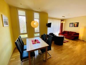- une salle à manger avec une table, des chaises et un canapé dans l'établissement Residenz/Sommerwind, à Warnemünde