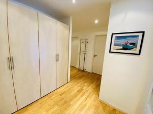 an empty room with white cabinets and wood floors at Residenz/Sommerwind in Warnemünde