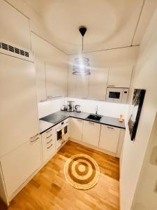 eine Küche mit weißen Schränken und Holzböden in der Unterkunft 2 Room / Central Railway / Free parking in Seinäjoki