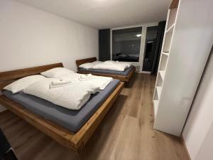 2 camas individuales en una habitación con ventana en Frisch renovierte Ferienwohnung, en Oberstaufen