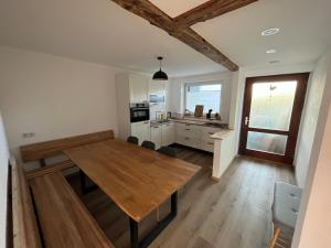 una cucina e una sala da pranzo con tavolo in legno di Frisch renovierte Ferienwohnung a Oberstaufen