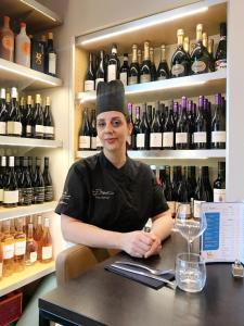 a woman sitting at a counter in a wine store at Auberge de Mourjou in Mourjou