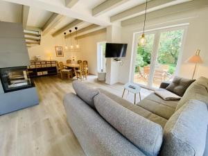 a living room with a large couch and a table at Sommerhaus am Bach in Warnemünde