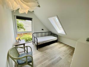 a attic room with a bed and a window at Sommerhaus am Bach in Warnemünde