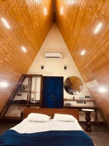 Cama en habitación con techo de madera en Tierra Villas Campsite -Udupi, en Padubidri