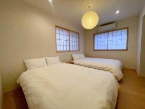 two beds in a room with two windows at GIVE Kagurazaka in Tokyo