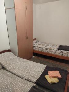 a bedroom with two beds and a cabinet and towels at Apartman Gogi in Zlatibor