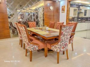 uma sala de jantar com uma mesa de madeira e cadeiras em Pratishtha 4BHK, DLF Phase 1, Gurgaon em Gurgaon