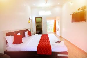 a bedroom with a large bed with red pillows at Leo Inn in Yercaud