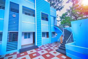 ein blaues Gebäude mit einer Treppe davor in der Unterkunft Leo Inn in Yercaud