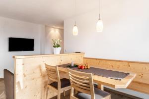 a dining room with a wooden table and chairs at Reiterhof Apt Gaia in San Genesio Atesino