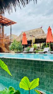 a resort with a swimming pool with umbrellas at Canal Village Pakpra Phatthalung in Phatthalung