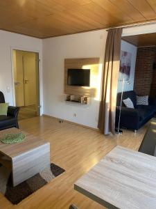 a living room with a couch and a tv on the wall at Ferienwohnung Familie Slepitzka in Niedenstein