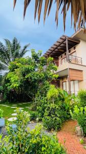 a house with a balcony and a garden at Canal Village Pakpra Phatthalung in Phatthalung