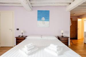 - une chambre blanche avec un grand lit blanc et 2 tables de chevet dans l'établissement Antico Casale Caroli, à Gattatico