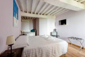 a white bedroom with a white bed and a tv at Antico Casale Caroli in Gattatico