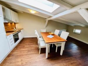 eine Küche mit einem Holztisch und weißen Stühlen in der Unterkunft Villa Seevogel/Lachmöwe in Warnemünde