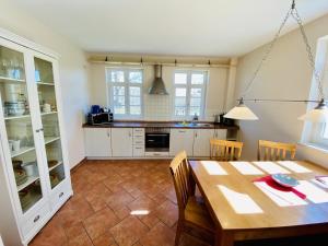 eine Küche mit einem Tisch und einem Esszimmer in der Unterkunft Wald & Meer/Kapitänsdeck in Warnemünde