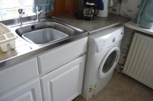 una cucina con lavello e lavatrice di Carnegie Holiday Cottage a Dunfermline