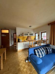 ein Wohnzimmer mit einem blauen Sofa und einer Küche in der Unterkunft Residence Zirmer in Kastelruth