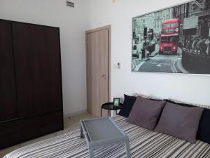 サレルノにあるSalerno Inn B&Bのベッドルーム1室(ベッド1台付)、赤いダブルデッカーバス