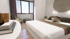 1 dormitorio con 2 camas y mesa en Philoxenia Hotel & Villas, en Pefkohori