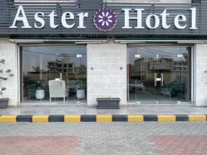a store front of a asier hotel with chairs in the windows at Aster Hotel Aqaba in Aqaba
