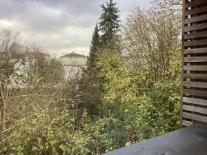 vistas a un jardín con árboles y arbustos en Paris centre en 15mn *3, en Nogent-sur-Marne