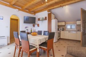 a kitchen and dining room with a table and chairs at Apartments Villa Maris in Lumbarda