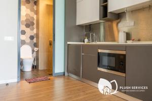 a kitchen with a sink and a microwave at CeylonZ Suites by Plush in Kuala Lumpur